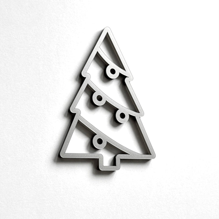 A simple, minimalist Christmas tree-shaped object made of a material that resembles a wire or metal.
