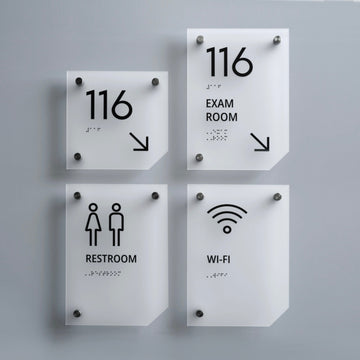a set of four restroom signs mounted to the side of a wall - Photo #10