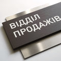 a close-up view of a dark wooden sign with white text on it. - Photo #3