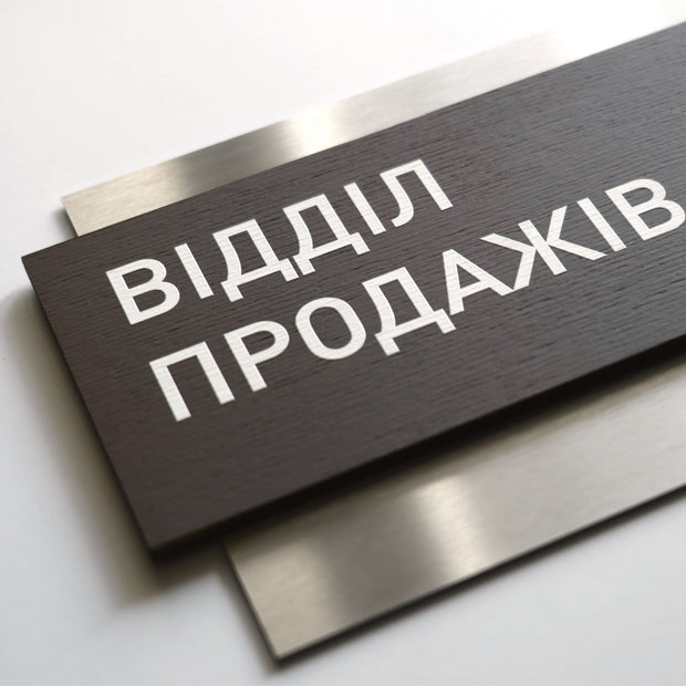 a close-up view of a dark wooden sign with white text on it.