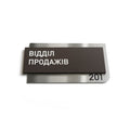 a dark brown rectangular sign with white text, which appears to be a nameplate or sign with a number on it. - Photo #10
