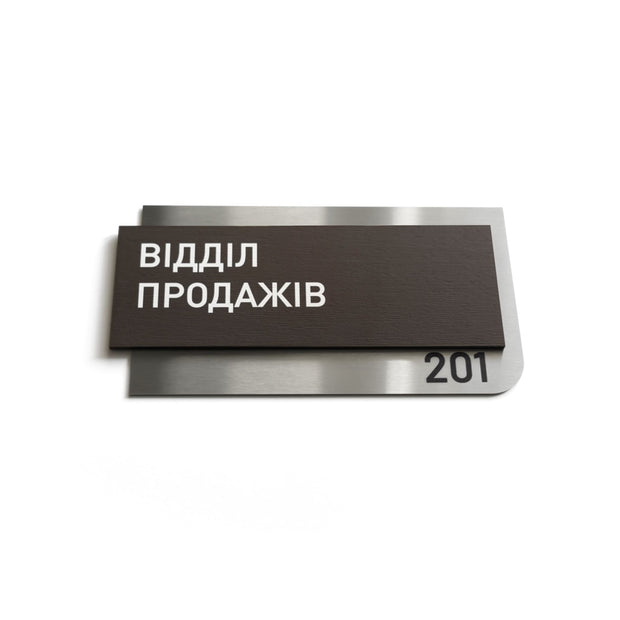 a dark brown rectangular sign with white text, which appears to be a nameplate or sign with a number on it.