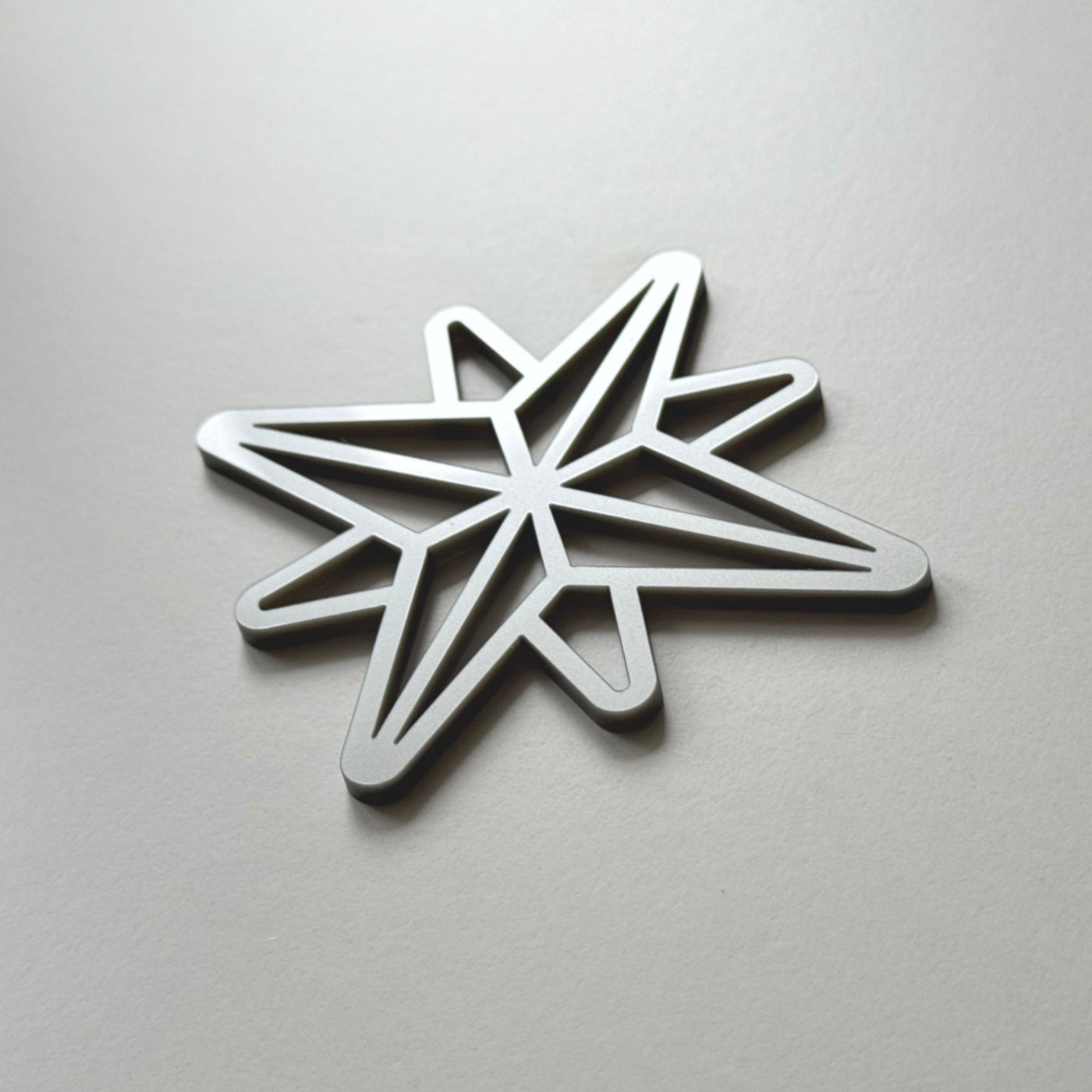 A silver star-shaped object is shown against a plain white background.