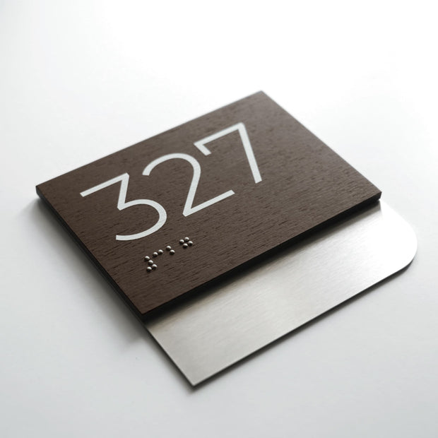 a dark brown sign with the number 327 and some Braille text on it.