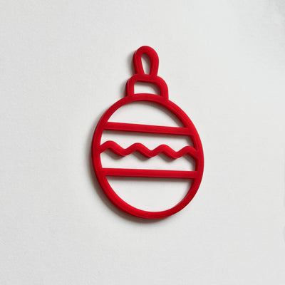A red Christmas ornament-like object with a wavy pattern on a white background.