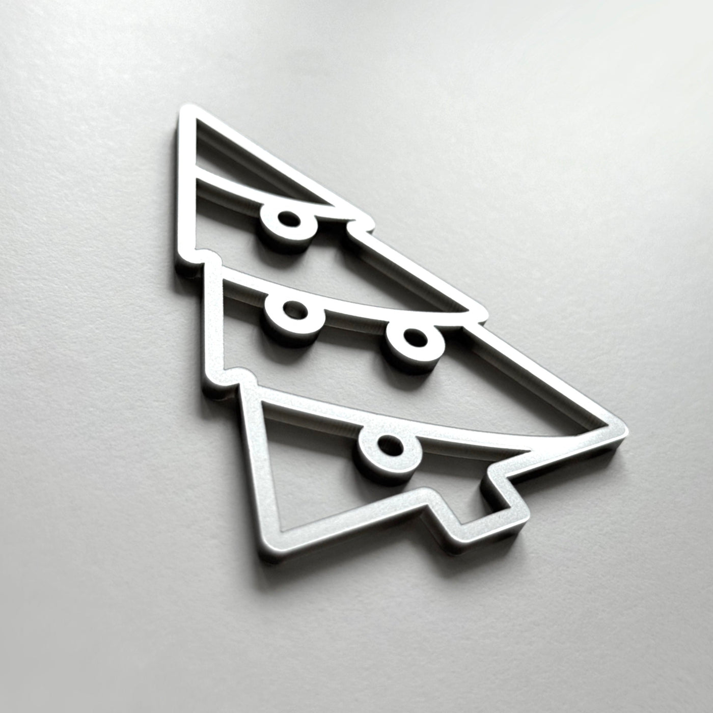 A stylized Christmas tree made of metal or plastic, with a simple and minimalist design.