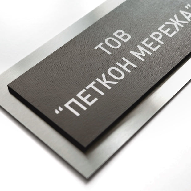 a close-up view of a black rectangular sign with white text on it.