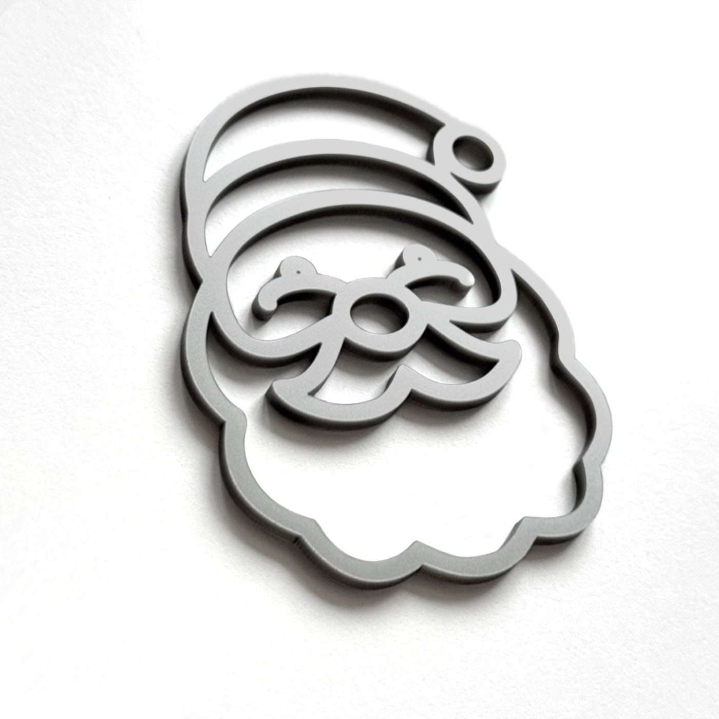 A stylized silhouette of a smiling face, resembling a cartoon or holiday-themed design, is shown against a plain white background.