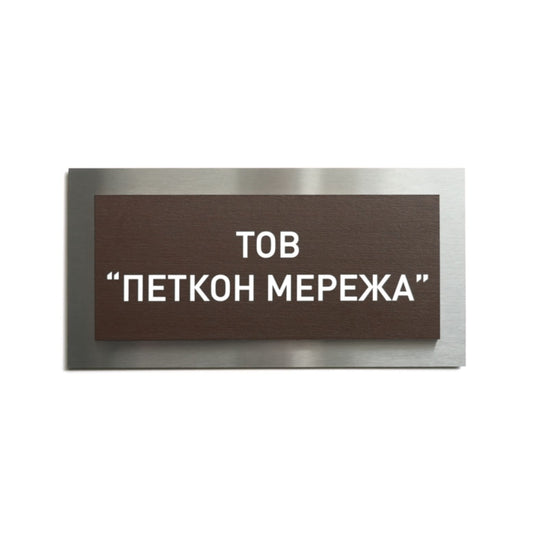 a rectangular brown sign with white text, which appears to be a sign with a foreign language. The sign is placed against a white background.