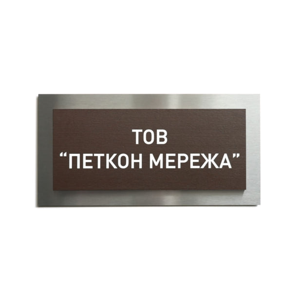 a rectangular brown sign with white text, which appears to be a sign with a foreign language. The sign is placed against a white background.