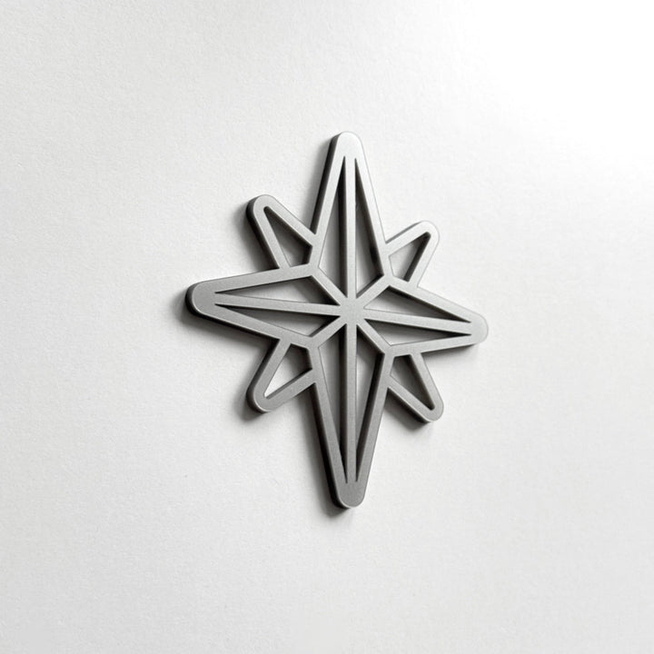 A silver star-shaped object is mounted on a white wall.