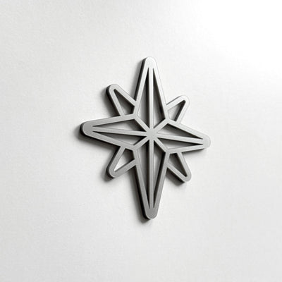 A silver star-shaped object is mounted on a white wall.