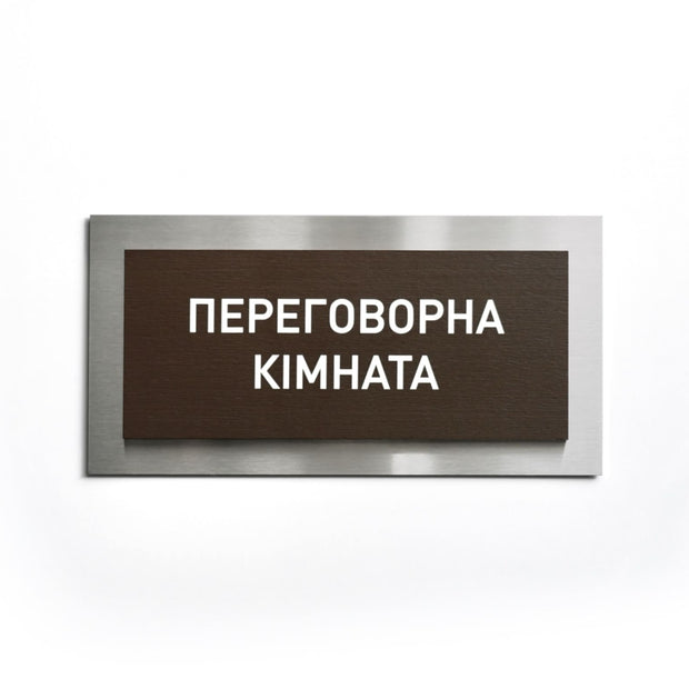 a rectangular sign with the text "Перемиума КОМАНАЯ" (Petrified Mountains) written in white.