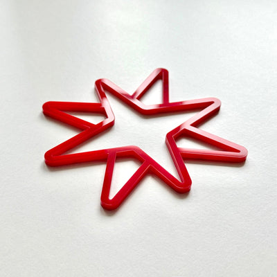 A red star-shaped object is placed on a white surface.