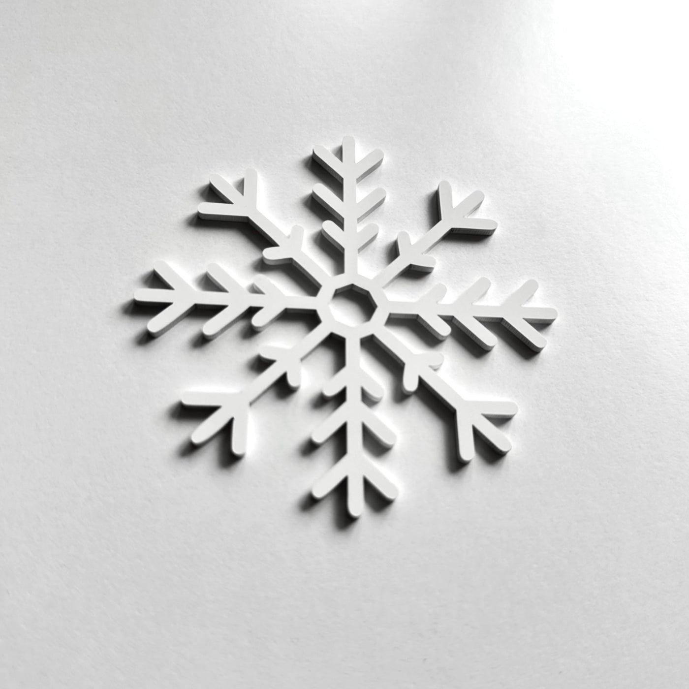 A white snowflake-shaped object is centered against a plain white background.