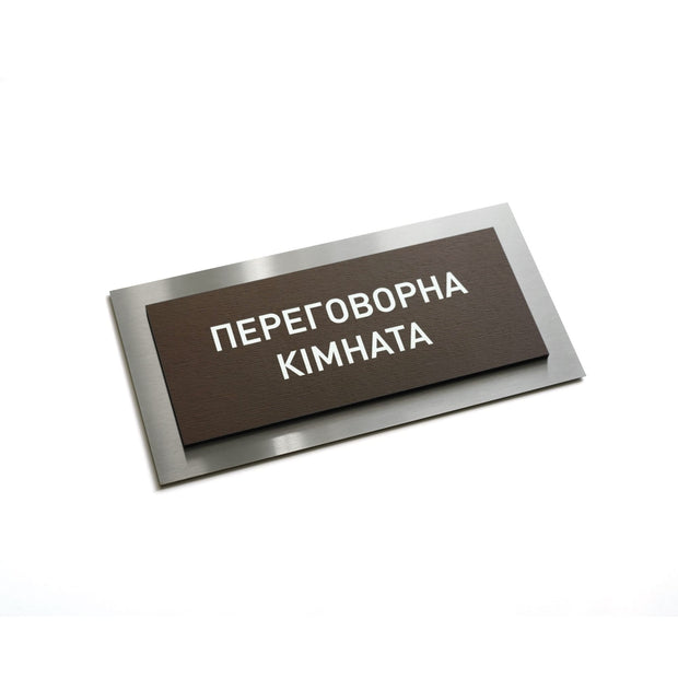 a rectangular brown sign with white text on it.