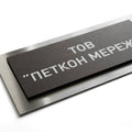 a black rectangular sign with white text on it. - Photo #7