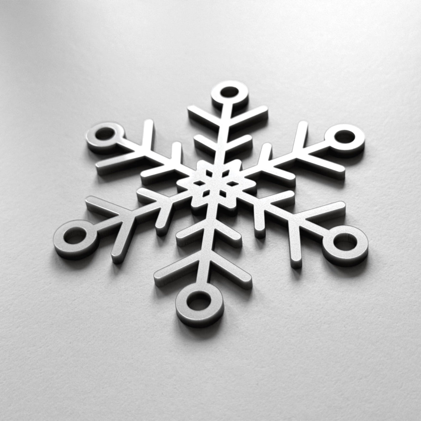 A close-up image of a snowflake-shaped object, which appears to be made of metal or a similar material.