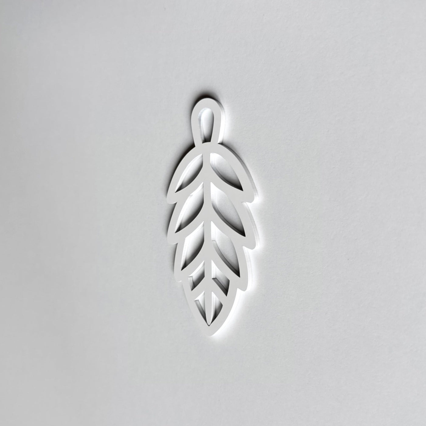 A white leaf-shaped object is centered against a plain white background.