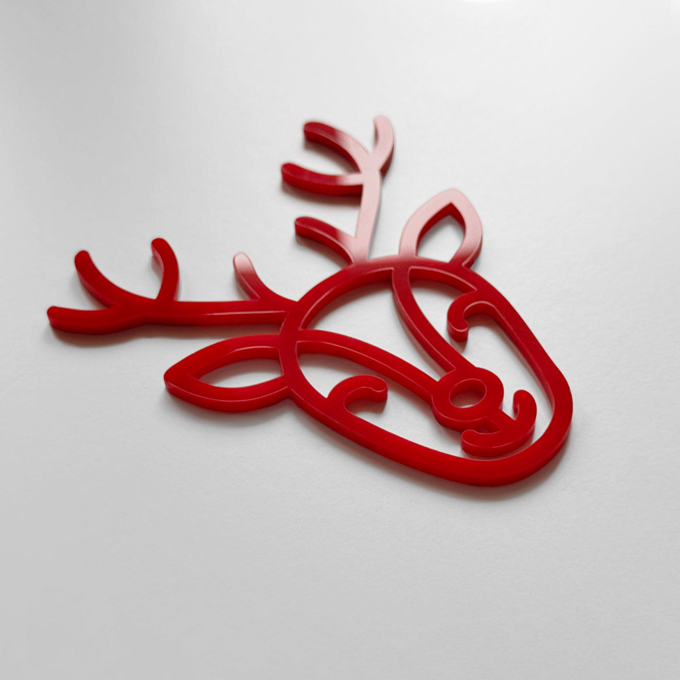 A red stylized deer head or antler shape is shown against a white background.