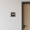 a door with a number plate attached to the wall above it. - Photo #2