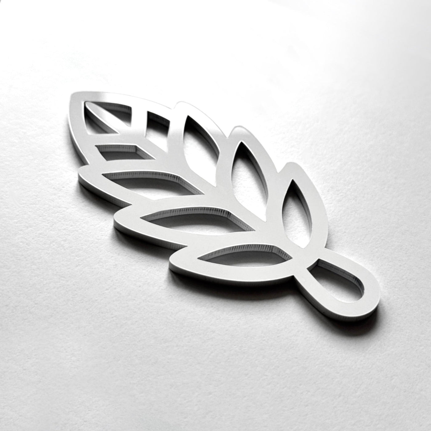 A 3D rendering of a stylized leaf-like shape in silver or metallic material.