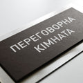 a close-up view of a black rectangular sign with white text on it. - Photo #2