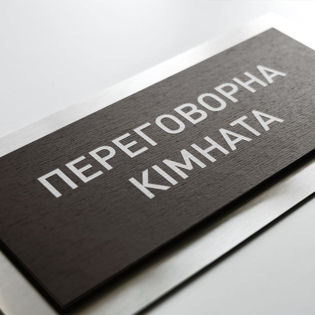 a close-up view of a black rectangular sign with white text on it.